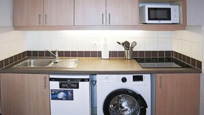 A compact kitchen with wooden cabinets, a built-in microwave, a dishwasher, and a washing machine. - Ski-in/ski-out & foot of the slopes, 6th floor, view mountain, swimming pool, sauna, balcony, tv (Les Orres)