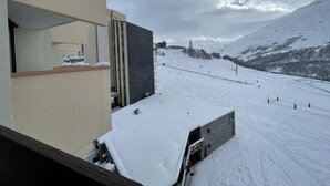 A snow-covered ski slope with a building in the foreground. - 10m from ski slopes, 6th floor, balcony, tv, ski locker, 19m², Les Menuires (Les Menuires)