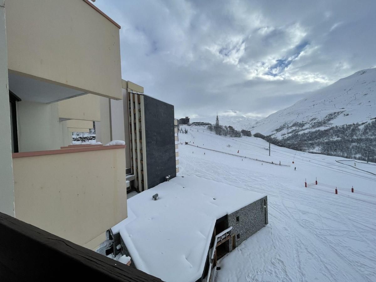 A snow-covered ski slope with a building in the foreground.