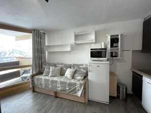 A compact living space with a sofa, a microwave, a small refrigerator, and a sink. - 10m from ski slopes, 6th floor, balcony, tv, ski locker, 19m², Les Menuires (Les Menuires)
