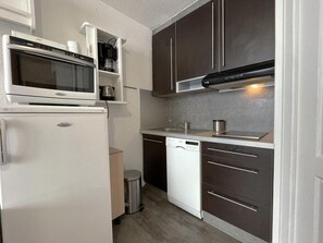 A compact kitchen with a microwave, oven, dishwasher, and dark cabinets. - 10m from ski slopes, 6th floor, balcony, tv, ski locker, 19m², Les Menuires (Les Menuires)
