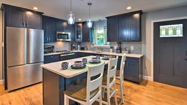 A modern kitchen with dark cabinets, stainless steel appliances, and pendant lighting. - Pensacola Backyard Oasis 
January 2026 Pool Renovation (Gulf Breeze)