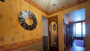 A room with a bed, a mirror, and a door leading to another room. - 350m from resort center, 1st floor, view ski slopes, balcony, tv, 40m², Montgenèvre (Montgenèvre)