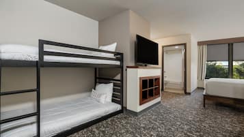 Hotelkamer met een stapelbed, een flatscreen televisie, een zithoekje en een groot raam.