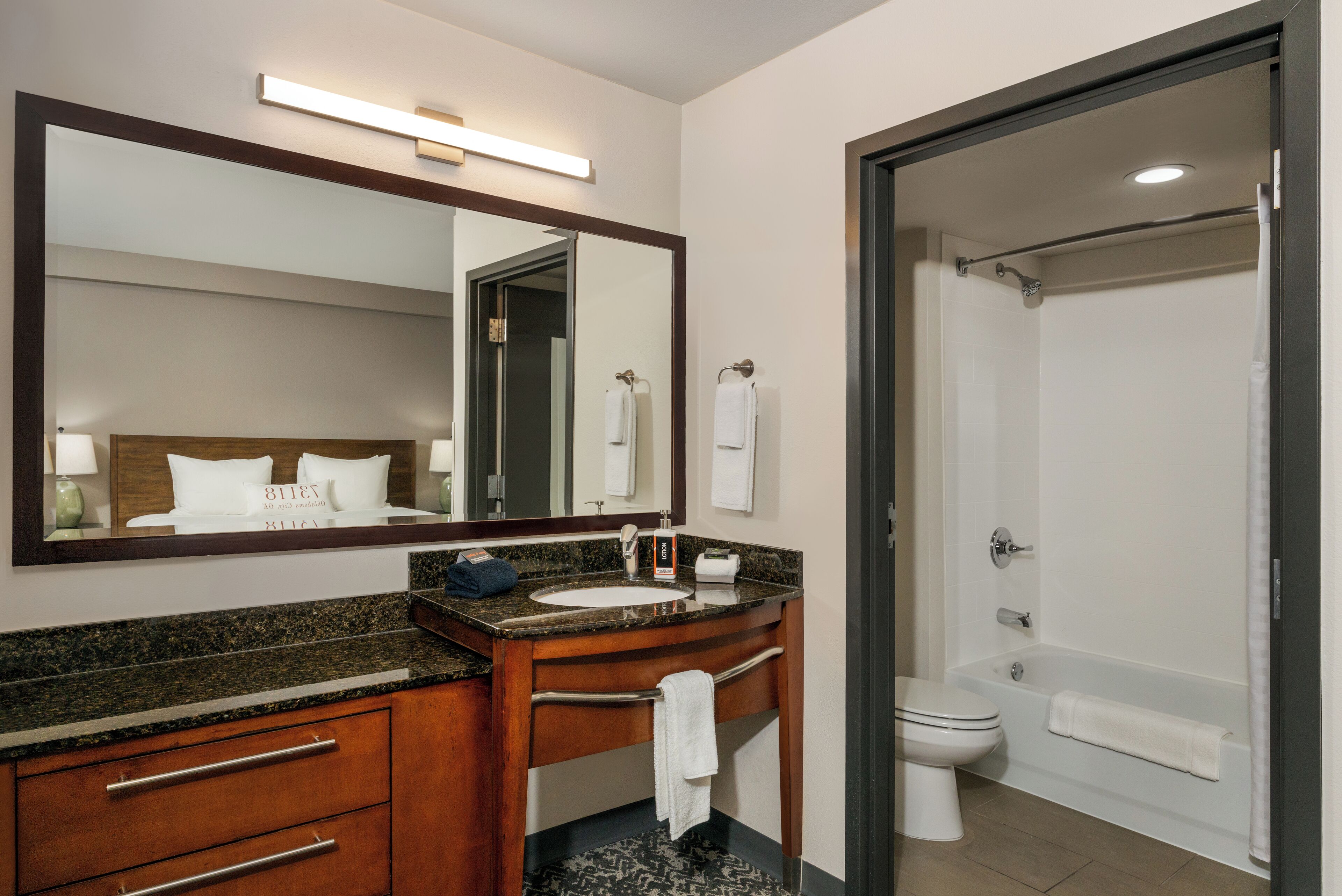 A bathroom with a sink, mirror, and toilet.