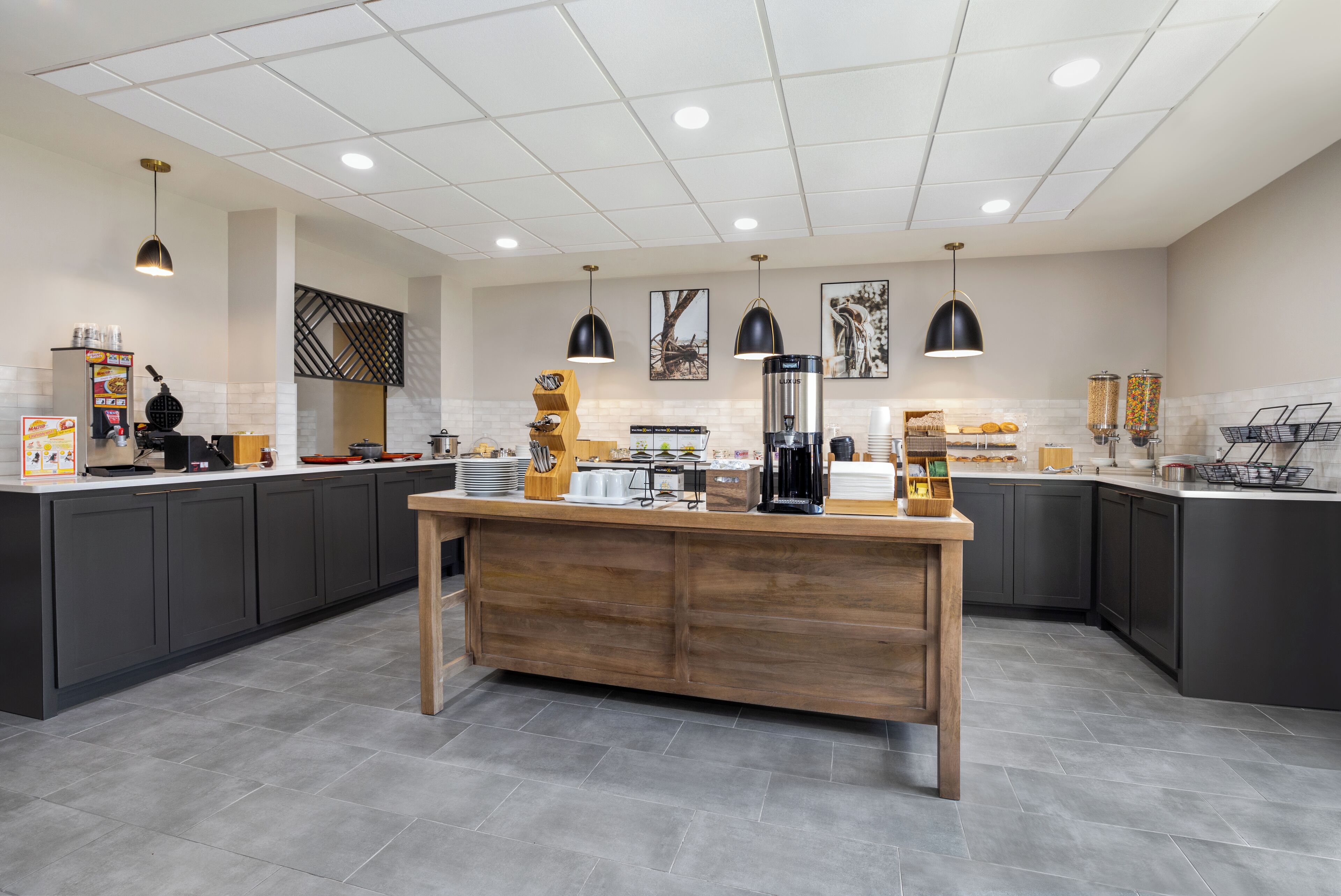 Una cocina moderna con armarios oscuros, una isla de madera y varios electrodomésticos.