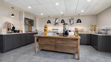 A modern kitchen with dark cabinets, a wooden island, and various appliances.