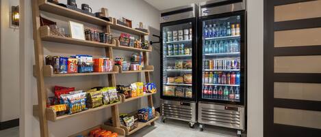 A well-stocked snack and beverage area with shelves of snacks and two beverage refrigerators.