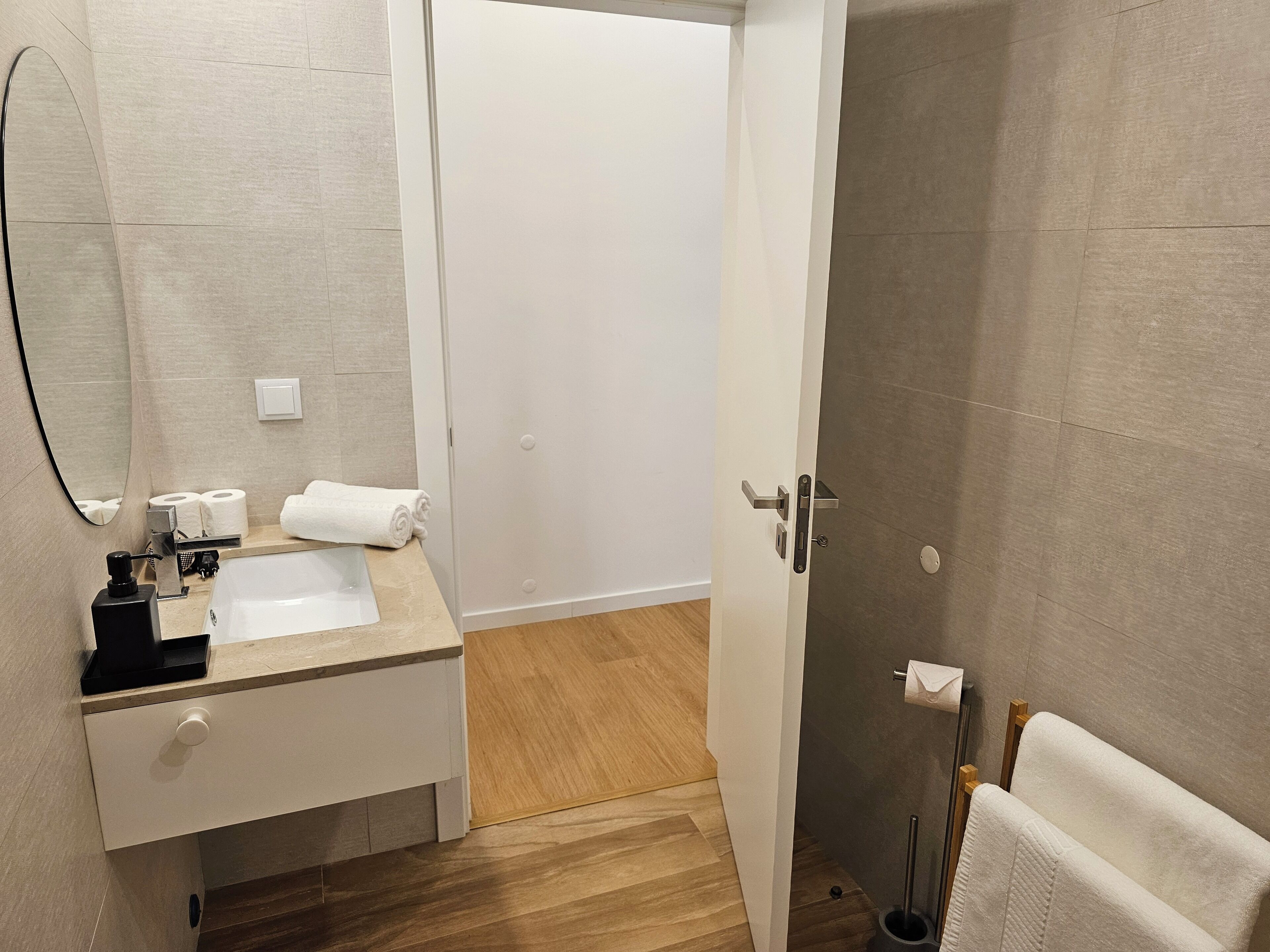 Casa de banho moderna com lavatório, espelho e porta-toalhas.