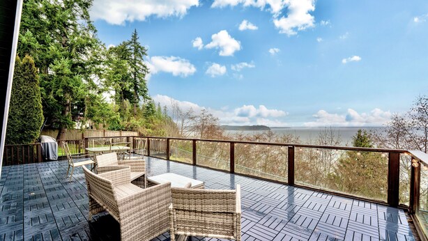 Una terraza con mobiliario de mimbre y vista al mar.