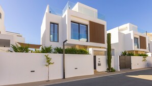A modern residential building with a flat roof, large windows, and a gated entrance. - Protaras Periyiali Seaside Villa 33 (Protaras)