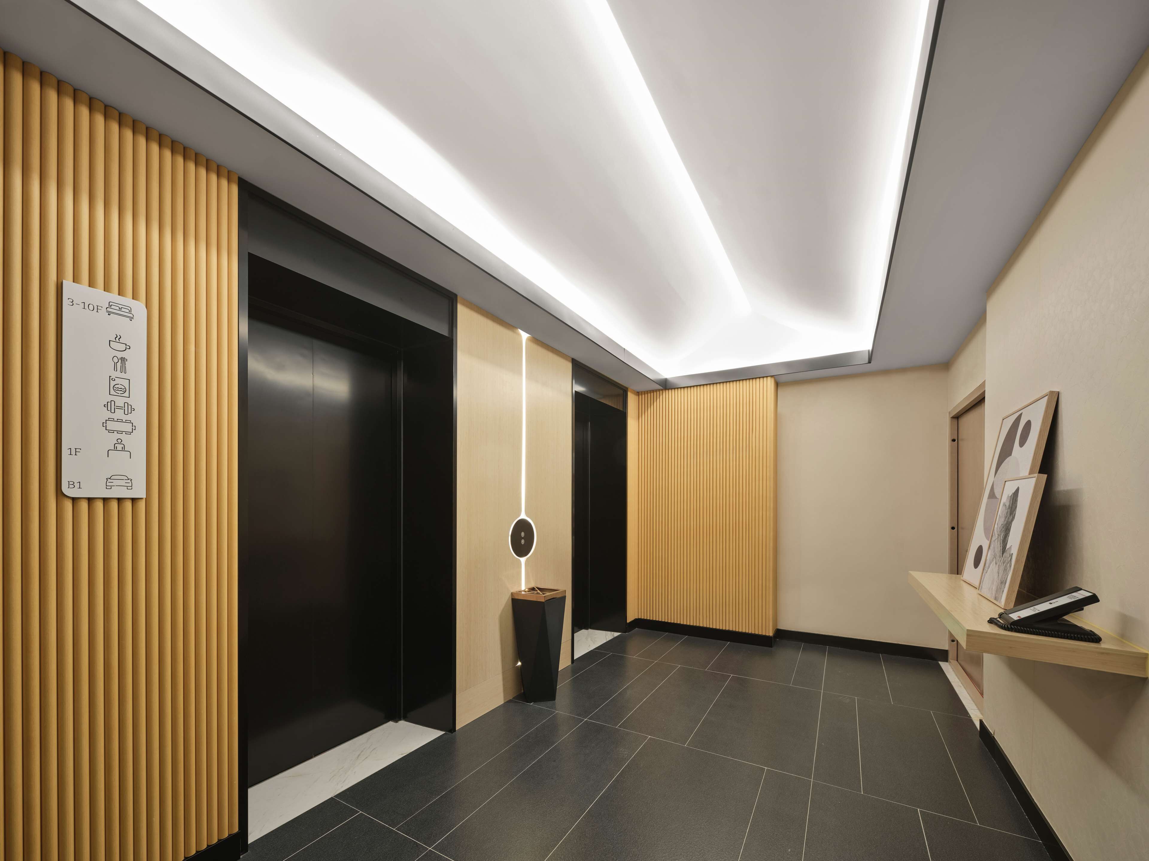 A modern elevator with a sign indicating floor levels and a control panel.
