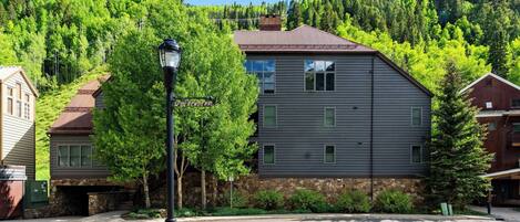 A modern two-story building with a stone foundation and a metal roof.