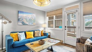 A cozy living room with a blue sofa, a wooden coffee table, and a map on the wall. -  Etta Place 6 by AvantStay | Ski In/ Ski Out Unit! (Telluride)