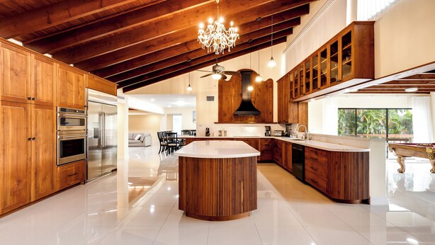 Una cucina moderna con mobili in legno, elettrodomestici in acciaio inossidabile e un'isola centrale.