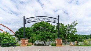 Une signalétique pour la promenade Hastings RiverWalk, avec une base en briques et une arche en métal.