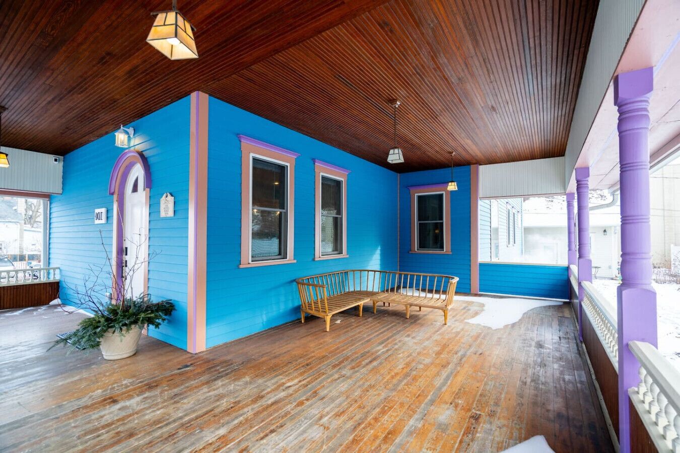 Una habitación con techo de madera, pared azul y un banco de madera.
