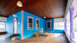 Une pièce avec un plafond en bois, un mur bleu et un banc en bois.