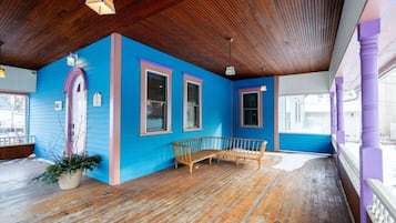 Una habitación con techo de madera, pared azul y un banco de madera.