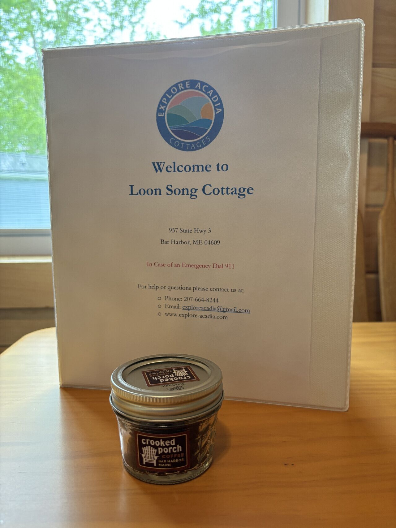 Un cartello di benvenuto per Loon Song Cottage con i recapiti e un barattolo di caffè Crooked Porch.