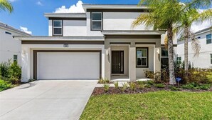 A modern two-story house with a garage, a front door, and a small porch area. - 588 - Great Family Home near Disney, private pool - Bellavida Resort (Kissimmee)