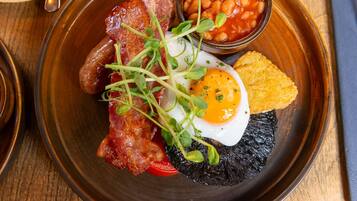 A breakfast plate with bacon, eggs, beans, and toast.