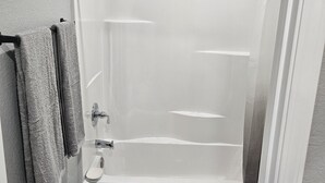 Un baño con bañera, inodoro y ducha.