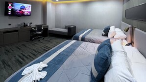 Una camera d'albergo moderna con un letto grande, una scrivania, una sedia e un televisore fissato alla parete.