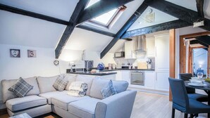 Un espacio habitable estilo loft con vigas a la vista, una cocina y un comedor.