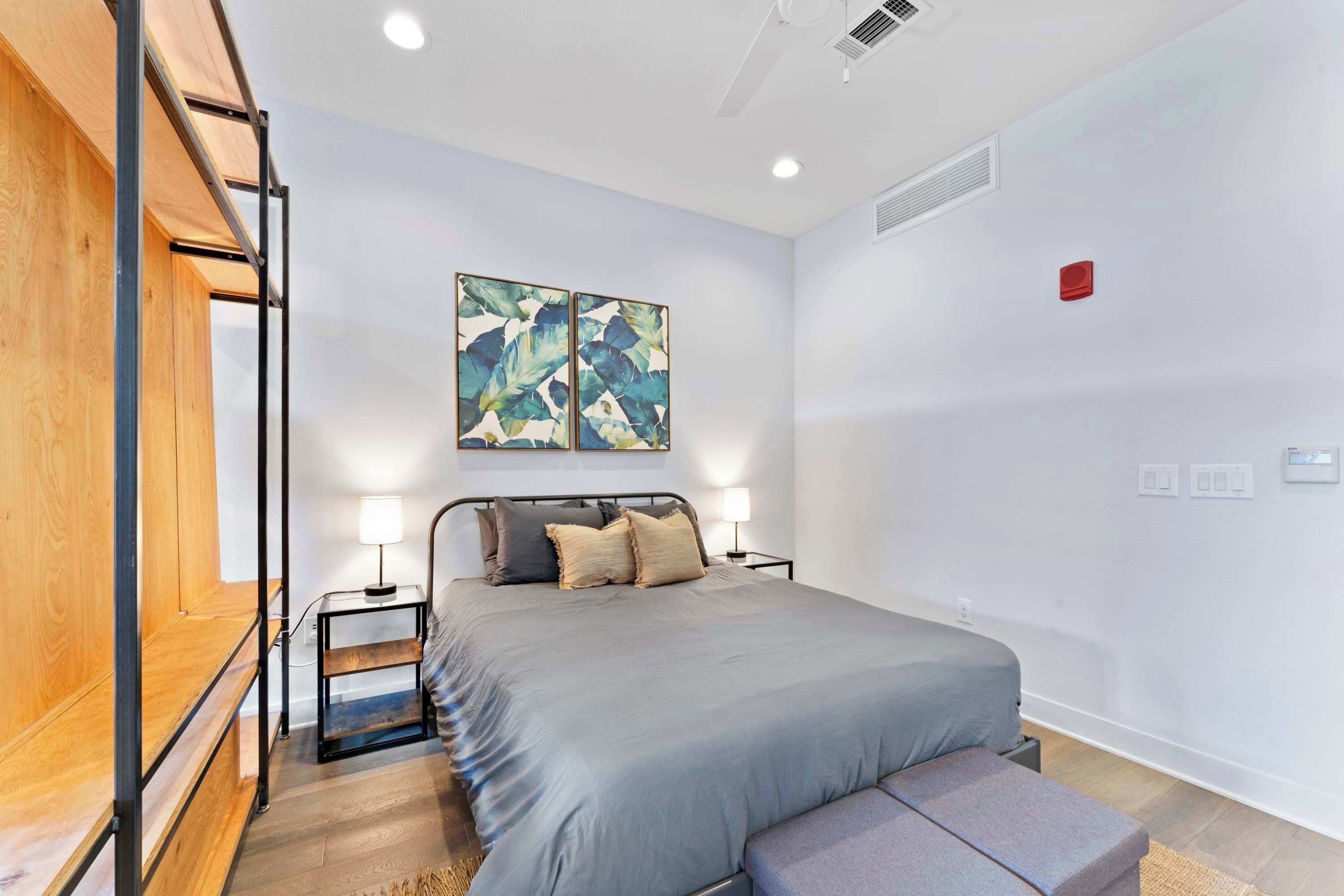 A modern bedroom with a bed, bedside tables, and a bench.