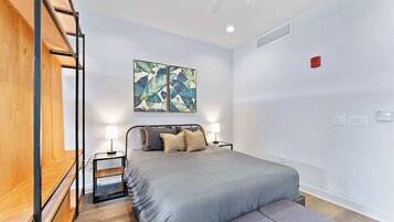 A modern bedroom with a bed, bedside tables, and a bench.