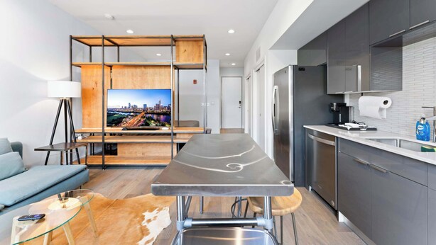 A modern kitchen with a built-in oven, a refrigerator, and a coffee machine.