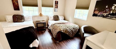 Une chambre avec deux lits, une petite table, une chaise et une fenêtre.