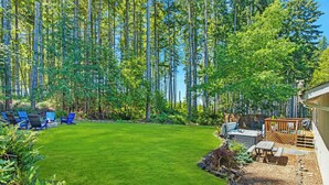 A backyard with a well-maintained lawn, a hot tub, and a wooden deck. - Hot Tub - Game Garage. Peaceful 1 Level Lake Limerick Retreat with Fire-pit. (Shelton)