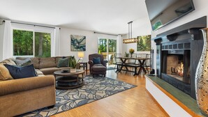 A living room with a sofa, armchair, coffee table, and fireplace. - Hot Tub - Game Garage. Peaceful 1 Level Lake Limerick Retreat with Fire-pit. (Shelton)