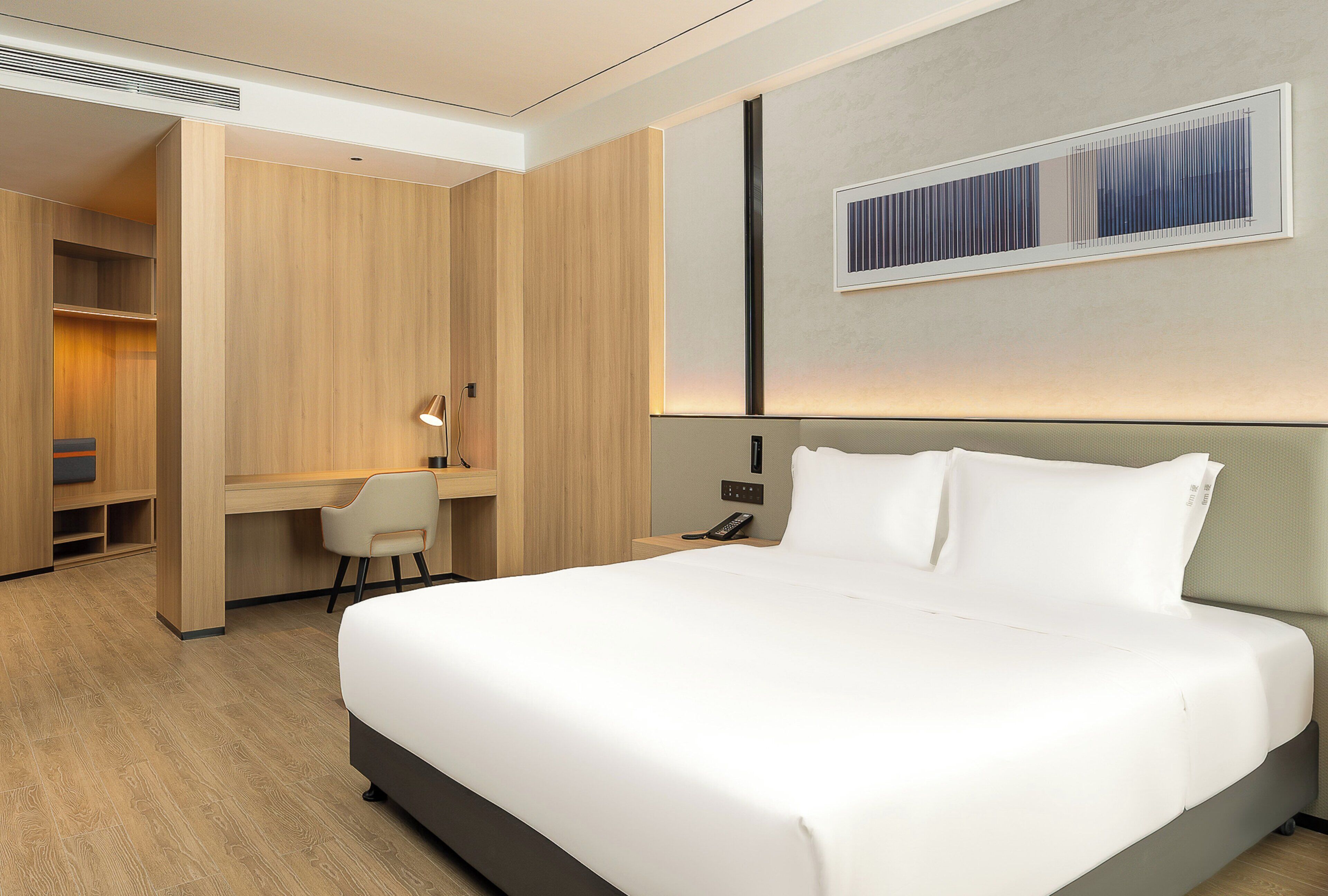 Una moderna camera d'hotel con un grande letto, una scrivania e una sedia.