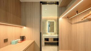 A modern bathroom with a wooden vanity, a mirror, a sink, and a towel rack.
