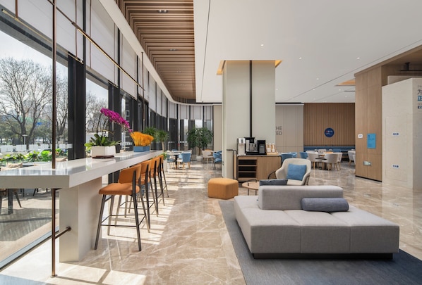 A modern hotel lobby with a bar area, seating, and a reception desk. - Holiday Inn Express Xi An Aerospace Town by IHG (Xi'an)