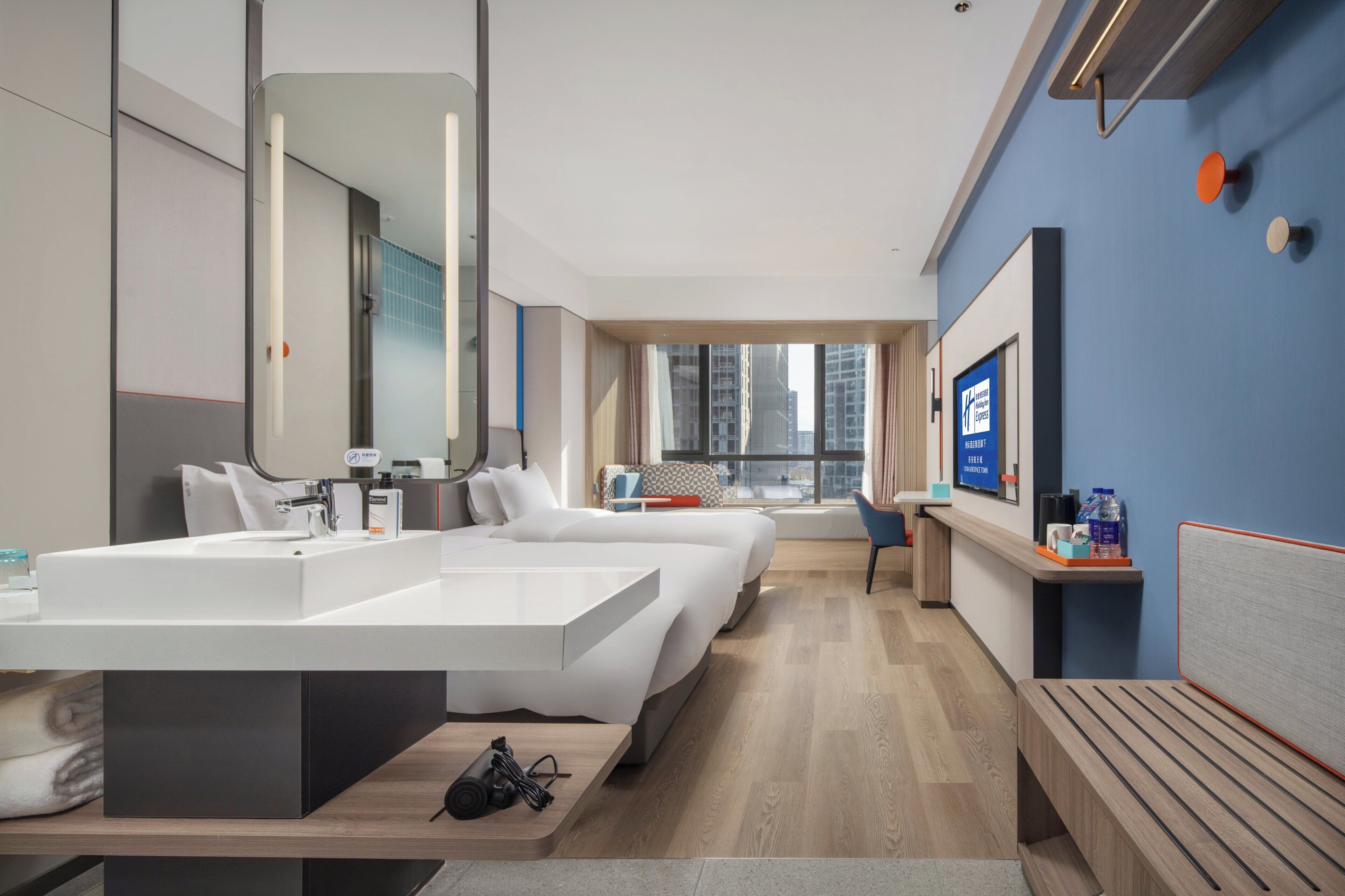 Una moderna camera d'hotel con bagno spazioso, una scrivania e vista sulla città.