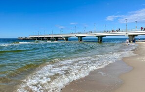 Une jetée qui s’avance dans l’eau, avec des gens qui la traversent à pied.