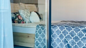 Un dormitorio con una cama, almohadas y una ventana.