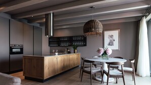 Una cocina moderna con una isla de madera, electrodomésticos de acero inoxidable y una lámpara colgante.
