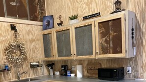 A kitchen with wooden cabinets, a built-in microwave, and a sink.