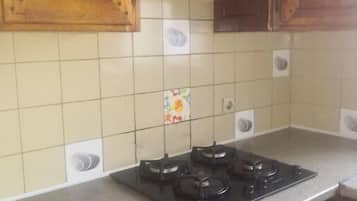 Een koelkast, een microgolfoven, kookgerei, borden en bestek