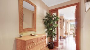 A hallway with a wooden dresser, a large mirror, and a potted plant. - Apartment 'La Bodegueta' with Private Terrace, Wi-Fi and Air Conditioning (Orba)