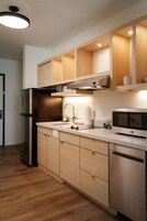 Una cocina moderna con armarios de madera, electrodomésticos de acero inoxidable y un horno empotrado.