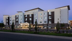 A multi-story hotel with a modern design, featuring a prominent entrance and a parking area in front. - TownePlace Suites by Marriott Denver North/Thornton (Thornton)