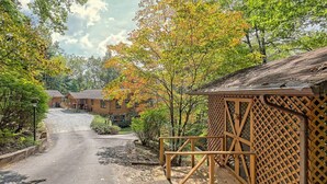 A rural road leading to a row of cabins with a wooden fence and lattice panels. - Peaceful, Spectacular Views, Screened Porch (Franklin, NC 28734)