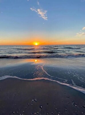 A beach with a sunset over the ocean. - Newly Renovated Gulf View Condo in Harbor House (St. Pete Beach)