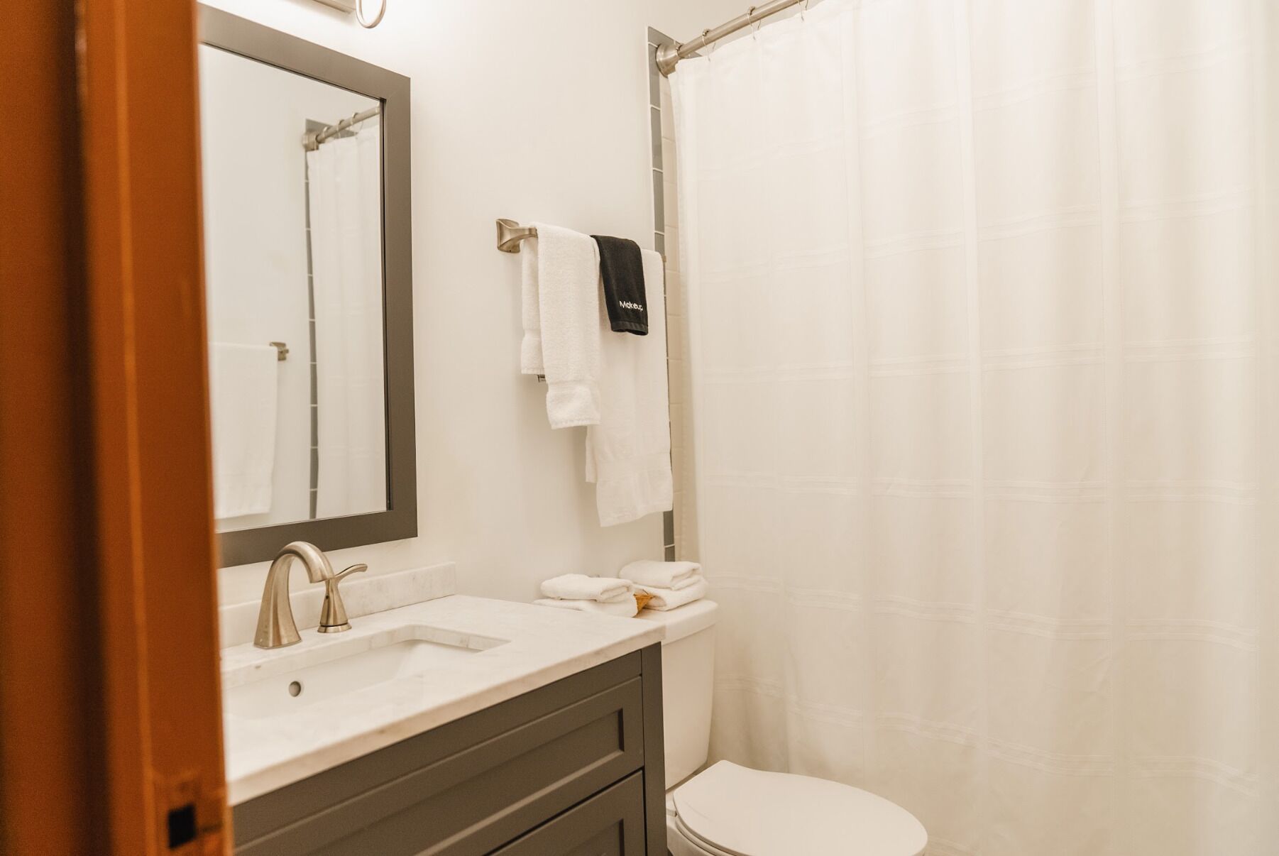 A bathroom with a sink, mirror, and toilet.